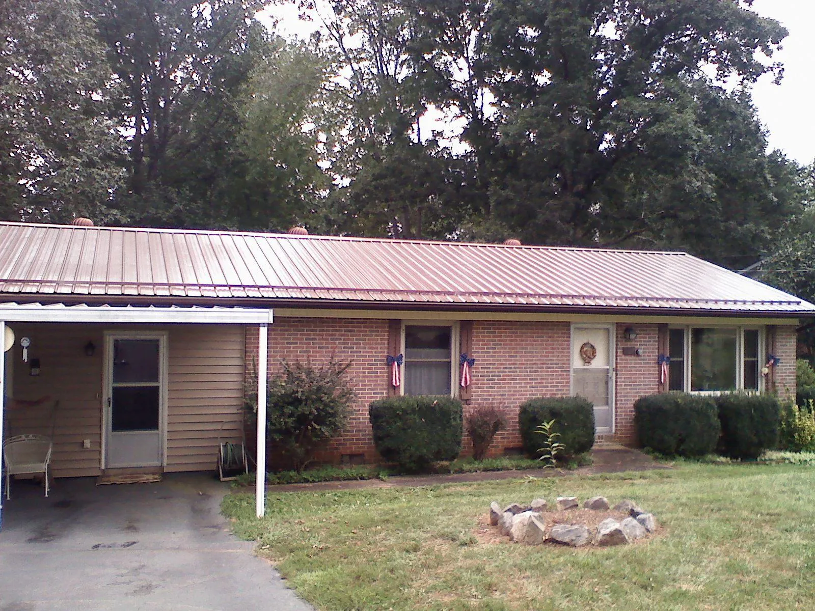 Bronze metal roof and carport on a brick ranch home — Roof Repair work by our crew in Glenwood